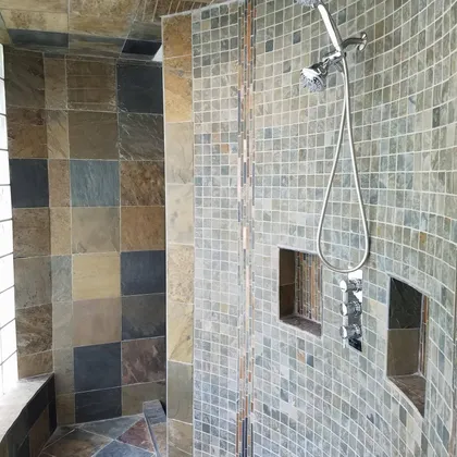 Stone shower enclosure with intricate tile work