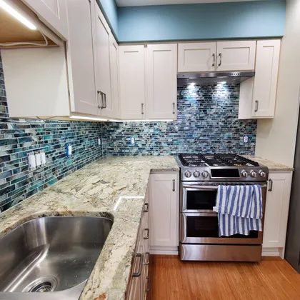 Kitchen with stone backsplash and stainless steel appliances