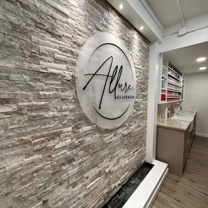 Elegant salon entrance with decorative stone wall and logo